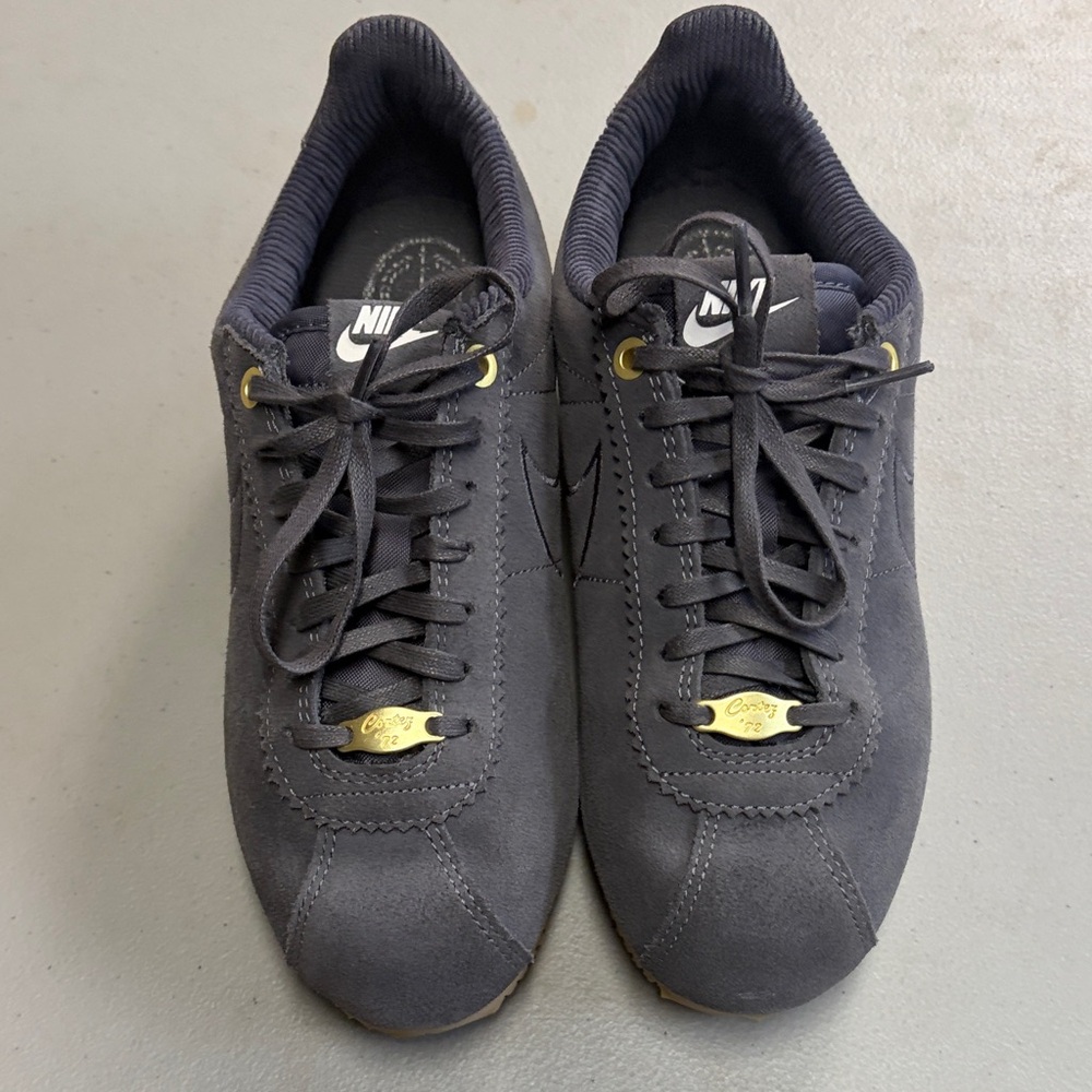 NWOB (never worn)Nike Ladies Black Suede Low-Profile Sneakers with Gold Accents